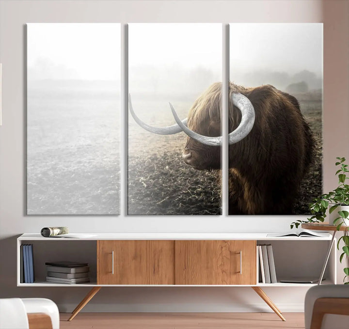 A captivating Cow Wall Art Canvas Print featuring a Highland cow with impressive horns in a misty field, crafted on museum-quality canvas. Its UV-protective coating preserves the artwork's vibrant colors.