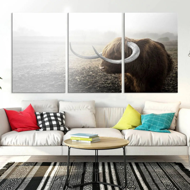 A captivating Cow Wall Art Canvas Print featuring a Highland cow with impressive horns in a misty field, crafted on museum-quality canvas. Its UV-protective coating preserves the artwork's vibrant colors.