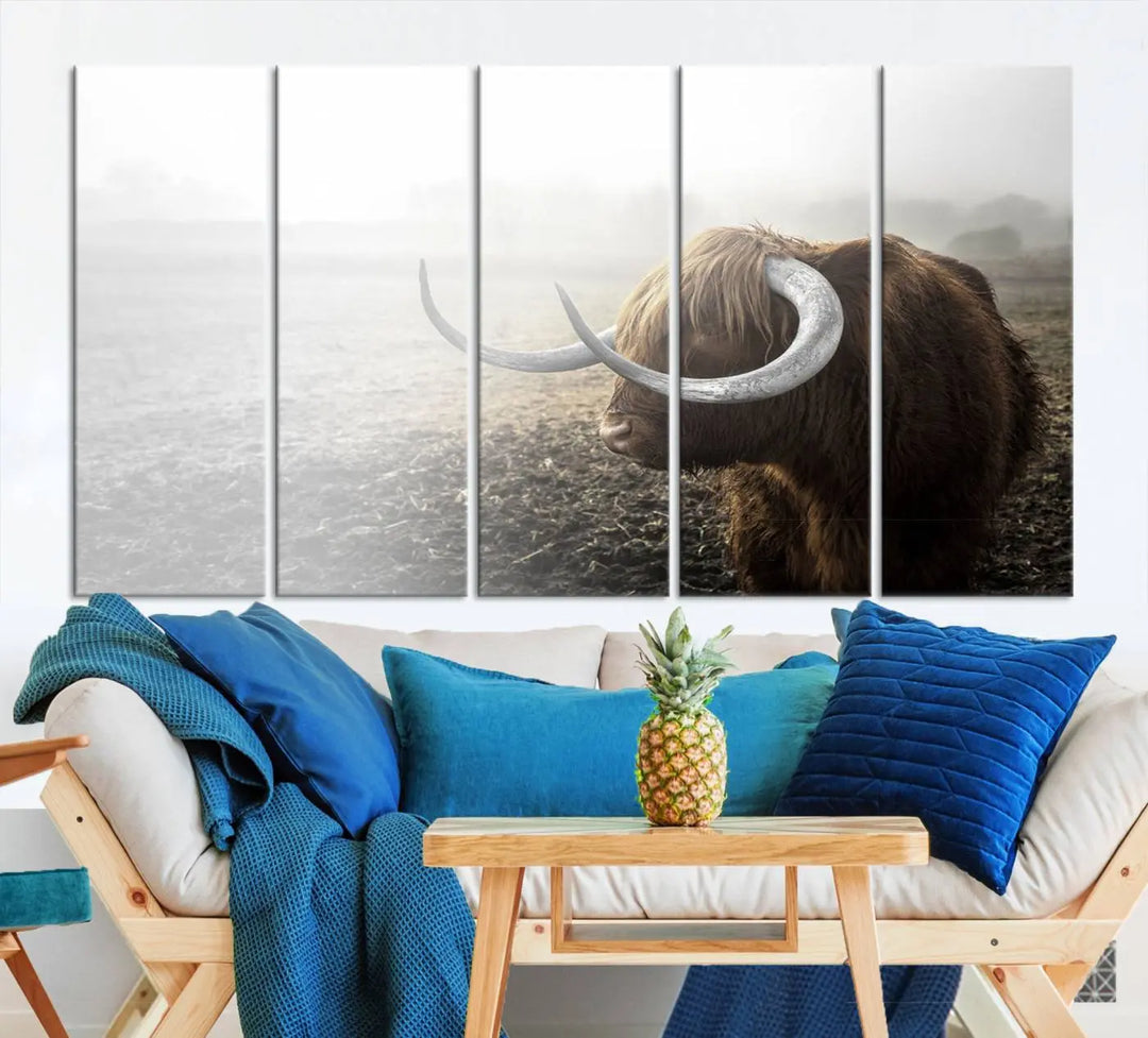 A captivating Cow Wall Art Canvas Print featuring a Highland cow with impressive horns in a misty field, crafted on museum-quality canvas. Its UV-protective coating preserves the artwork's vibrant colors.