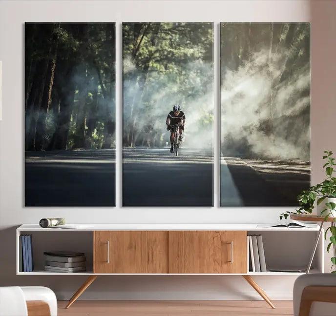 A cyclist rides through a misty forest in the "Cycling Road Bike in the Morning" artwork, divided into three panels on gallery-wrapped, museum-quality canvas.