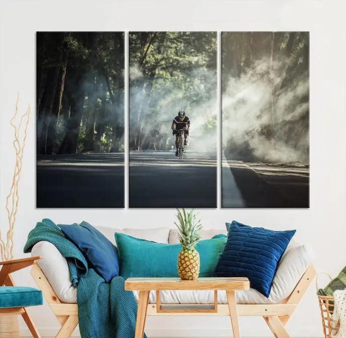 A cyclist rides through a misty forest in the "Cycling Road Bike in the Morning" artwork, divided into three panels on gallery-wrapped, museum-quality canvas.