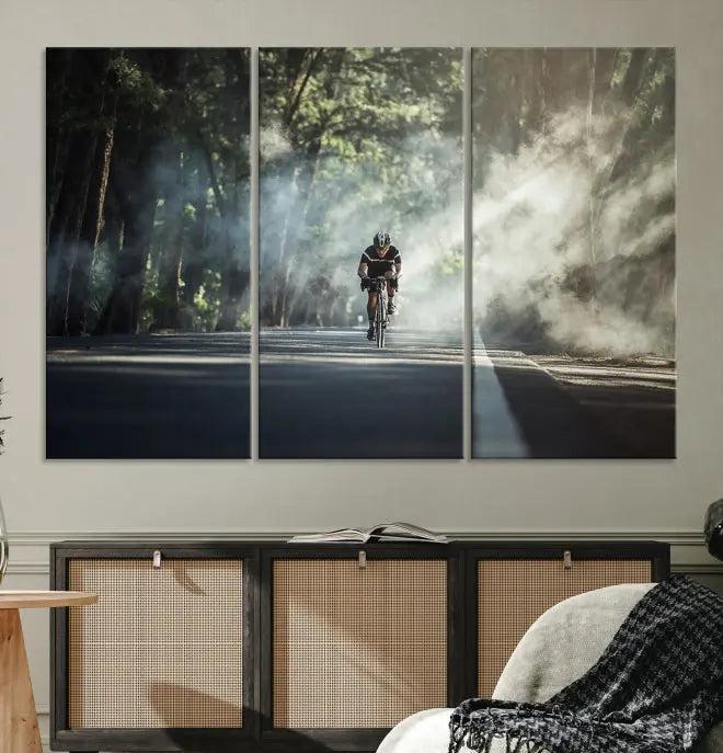 A cyclist rides through a misty forest in the "Cycling Road Bike in the Morning" artwork, divided into three panels on gallery-wrapped, museum-quality canvas.