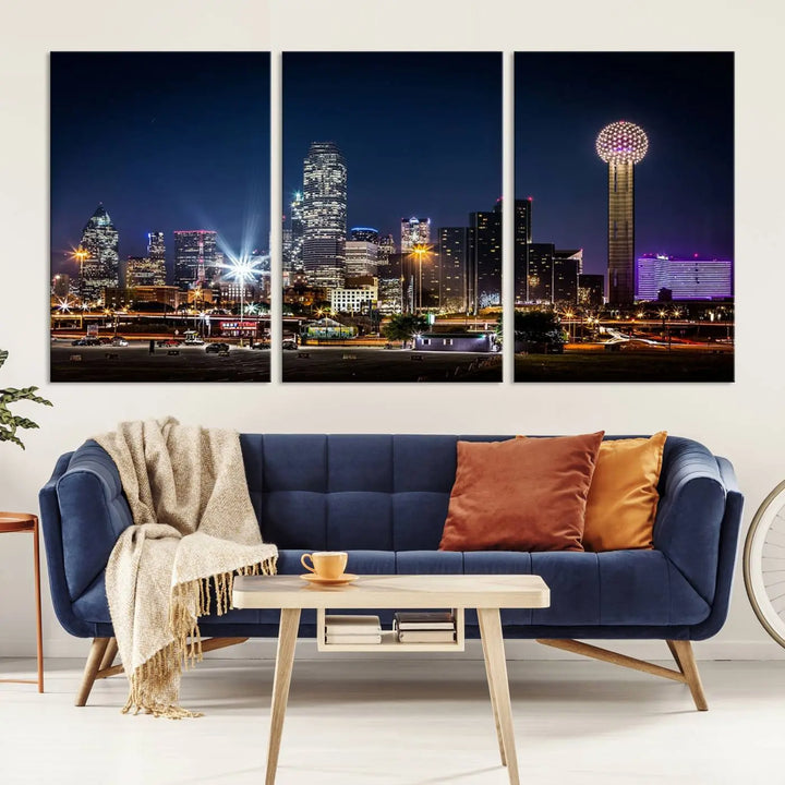 A living room showcases the Dallas City Lights Night Skyline Cityscape View Wall Art Canvas Print, a triptych photo of a city skyline at night on museum-quality canvas that is ready to hang.