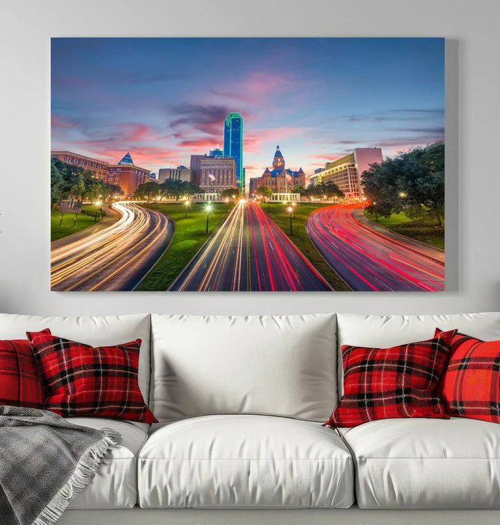 A modern living room features a cityscape triptych wall art titled "Dallas City Street Lights Sunset Pink Cloudy Skyline Cityscape View," printed on museum-quality canvas. It captures a vibrant evening skyline with light trails.