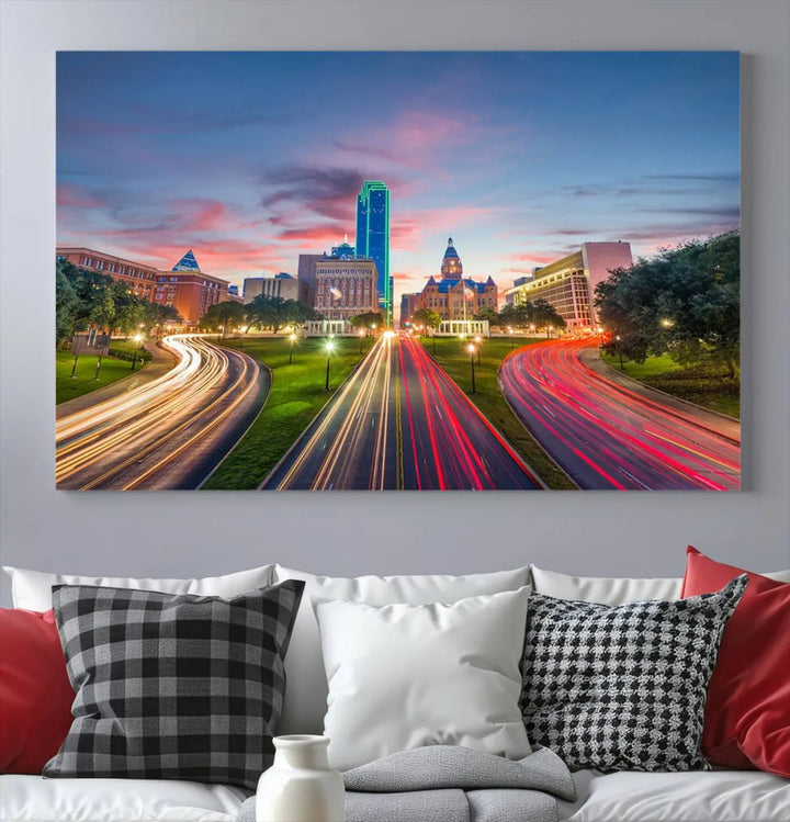 A modern living room features a cityscape triptych wall art titled "Dallas City Street Lights Sunset Pink Cloudy Skyline Cityscape View," printed on museum-quality canvas. It captures a vibrant evening skyline with light trails.