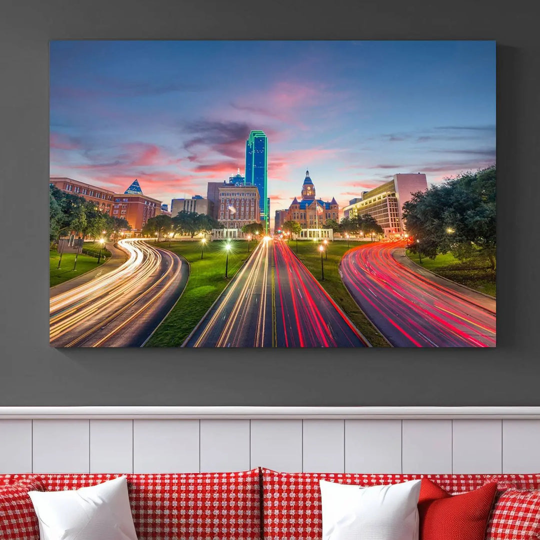 A modern living room features a cityscape triptych wall art titled "Dallas City Street Lights Sunset Pink Cloudy Skyline Cityscape View," printed on museum-quality canvas. It captures a vibrant evening skyline with light trails.