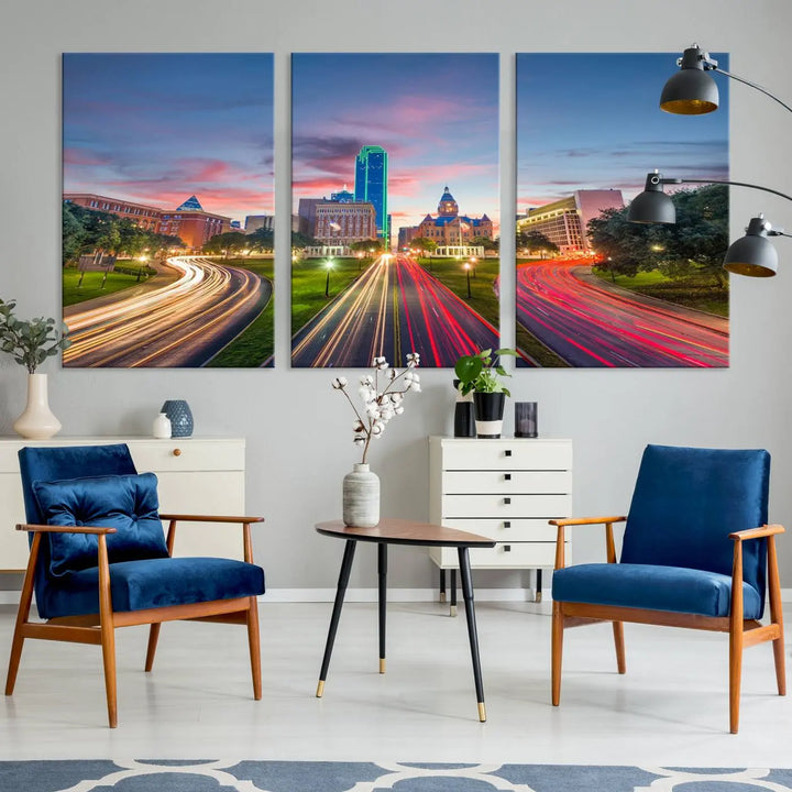 A modern living room features a cityscape triptych wall art titled "Dallas City Street Lights Sunset Pink Cloudy Skyline Cityscape View," printed on museum-quality canvas. It captures a vibrant evening skyline with light trails.