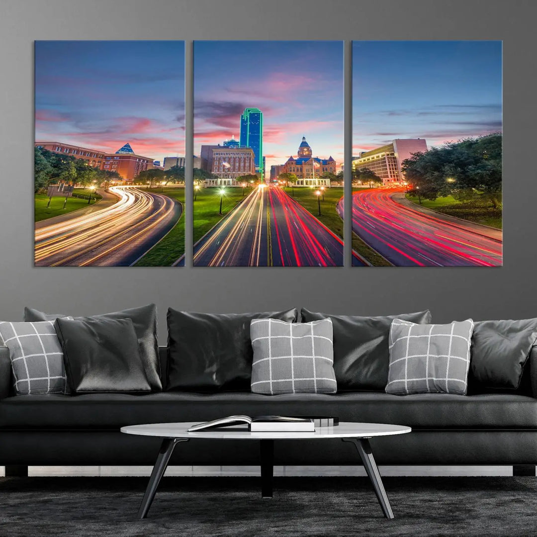 A modern living room features a cityscape triptych wall art titled "Dallas City Street Lights Sunset Pink Cloudy Skyline Cityscape View," printed on museum-quality canvas. It captures a vibrant evening skyline with light trails.