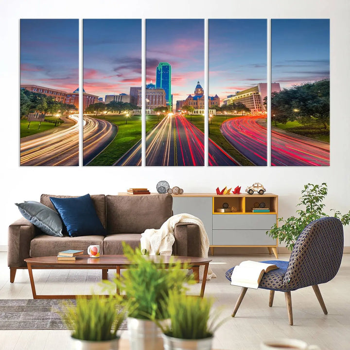 A modern living room features a cityscape triptych wall art titled "Dallas City Street Lights Sunset Pink Cloudy Skyline Cityscape View," printed on museum-quality canvas. It captures a vibrant evening skyline with light trails.