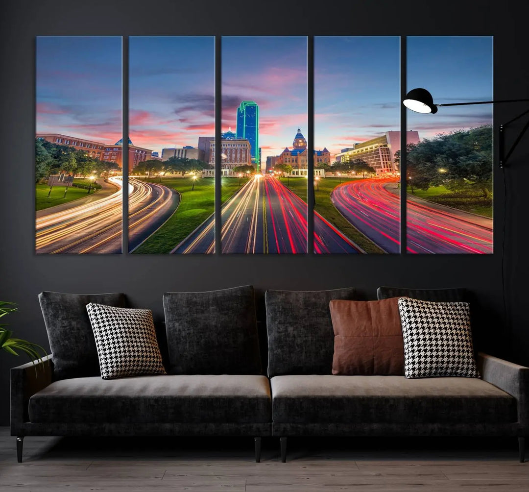 A modern living room features a cityscape triptych wall art titled "Dallas City Street Lights Sunset Pink Cloudy Skyline Cityscape View," printed on museum-quality canvas. It captures a vibrant evening skyline with light trails.