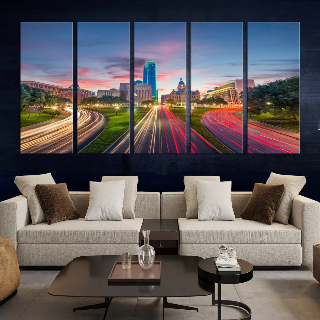 A modern living room features a cityscape triptych wall art titled "Dallas City Street Lights Sunset Pink Cloudy Skyline Cityscape View," printed on museum-quality canvas. It captures a vibrant evening skyline with light trails.