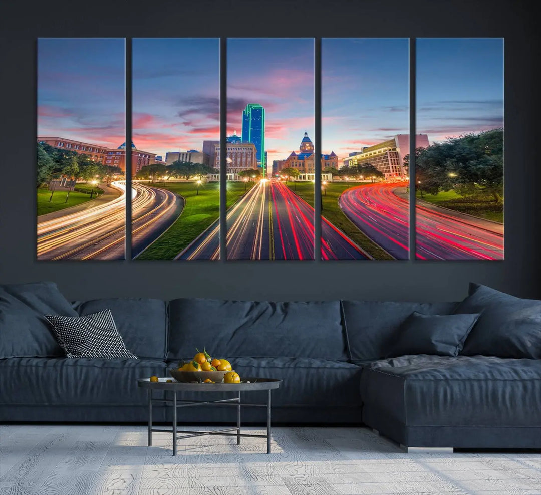 A modern living room features a cityscape triptych wall art titled "Dallas City Street Lights Sunset Pink Cloudy Skyline Cityscape View," printed on museum-quality canvas. It captures a vibrant evening skyline with light trails.