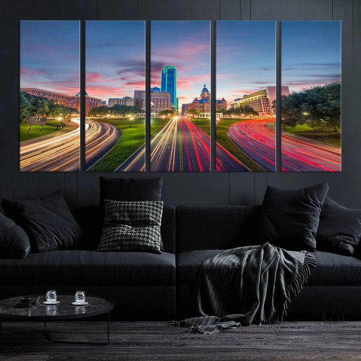 A modern living room features a cityscape triptych wall art titled "Dallas City Street Lights Sunset Pink Cloudy Skyline Cityscape View," printed on museum-quality canvas. It captures a vibrant evening skyline with light trails.