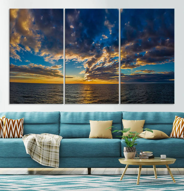 In a cozy living room, the Dark Clouds on the Ocean Beach Sunset Wall Art Canvas Print, featuring three panels and a museum-quality finish, hangs prominently.