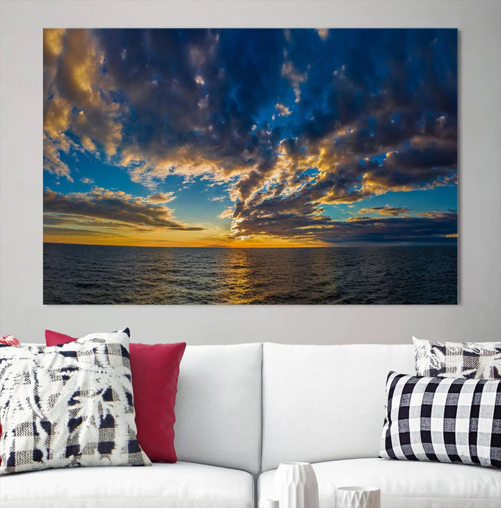 In a cozy living room, the Dark Clouds on the Ocean Beach Sunset Wall Art Canvas Print, featuring three panels and a museum-quality finish, hangs prominently.