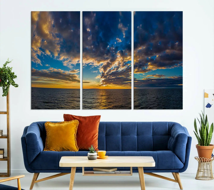 In a cozy living room, the Dark Clouds on the Ocean Beach Sunset Wall Art Canvas Print, featuring three panels and a museum-quality finish, hangs prominently.