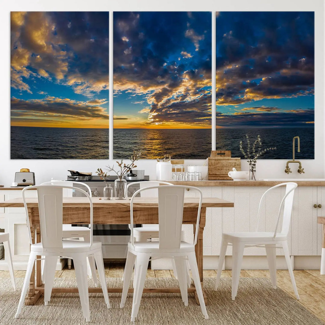 In a cozy living room, the Dark Clouds on the Ocean Beach Sunset Wall Art Canvas Print, featuring three panels and a museum-quality finish, hangs prominently.