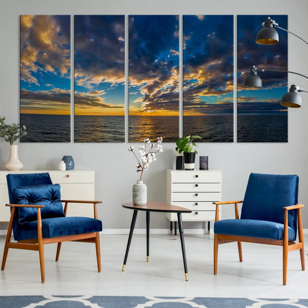 In a cozy living room, the Dark Clouds on the Ocean Beach Sunset Wall Art Canvas Print, featuring three panels and a museum-quality finish, hangs prominently.