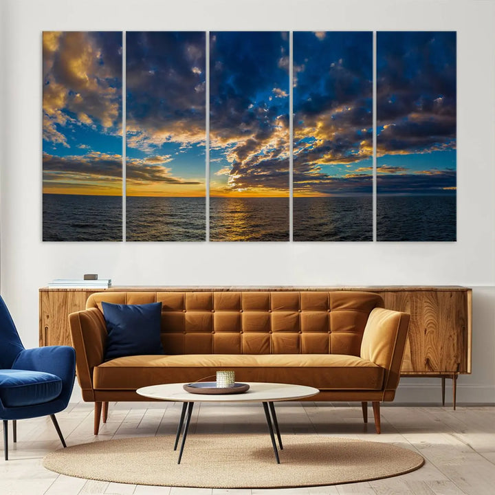 In a cozy living room, the Dark Clouds on the Ocean Beach Sunset Wall Art Canvas Print, featuring three panels and a museum-quality finish, hangs prominently.