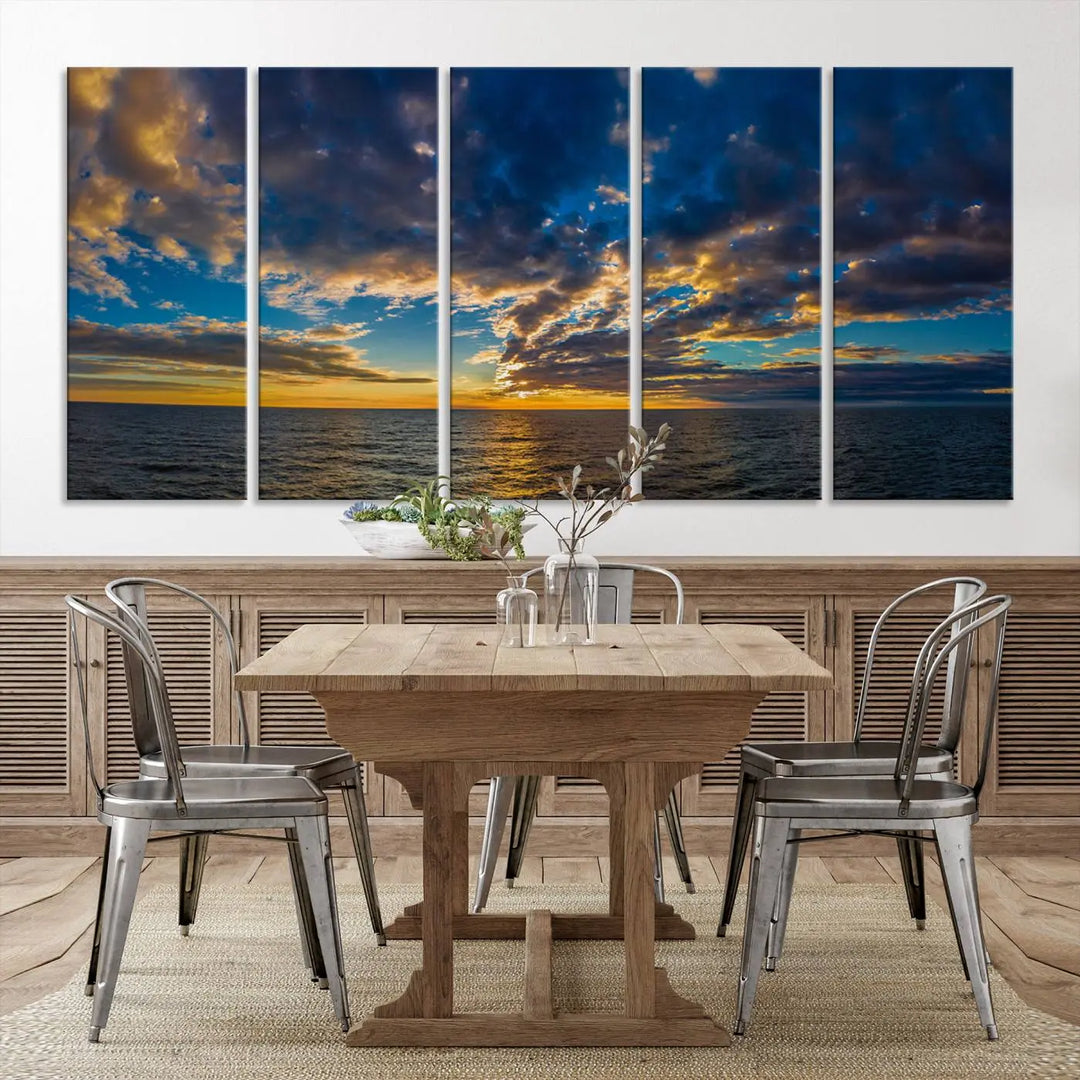 In a cozy living room, the Dark Clouds on the Ocean Beach Sunset Wall Art Canvas Print, featuring three panels and a museum-quality finish, hangs prominently.