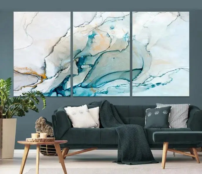 An abstract triptych of the Dark Turquoise Marble Fluid Effect on museum-quality canvas enhances the living room.