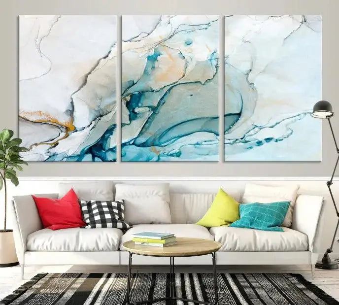 An abstract triptych of the Dark Turquoise Marble Fluid Effect on museum-quality canvas enhances the living room.