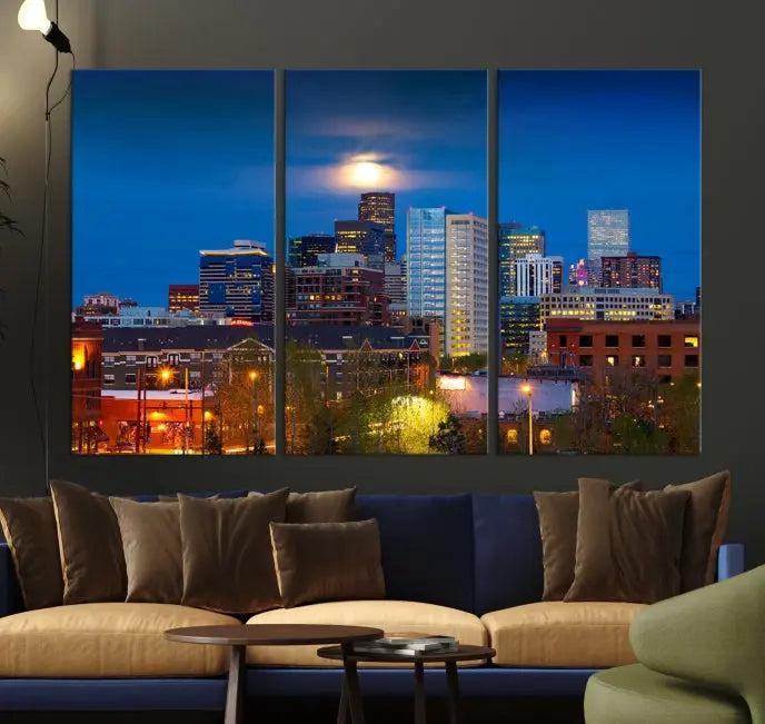 The Denver City Lights Night Blue Skyline Cityscape View Wall Art Canvas Print captures a stunning skyline at night with illuminated buildings and a bright moon, presented on gallery-quality canvas for an elegant display.