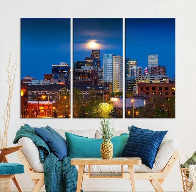 The Denver City Lights Night Blue Skyline Cityscape View Wall Art Canvas Print captures a stunning skyline at night with illuminated buildings and a bright moon, presented on gallery-quality canvas for an elegant display.