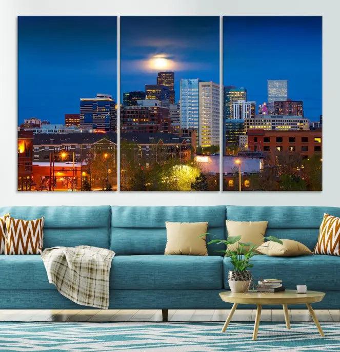 The Denver City Lights Night Blue Skyline Cityscape View Wall Art Canvas Print captures a stunning skyline at night with illuminated buildings and a bright moon, presented on gallery-quality canvas for an elegant display.