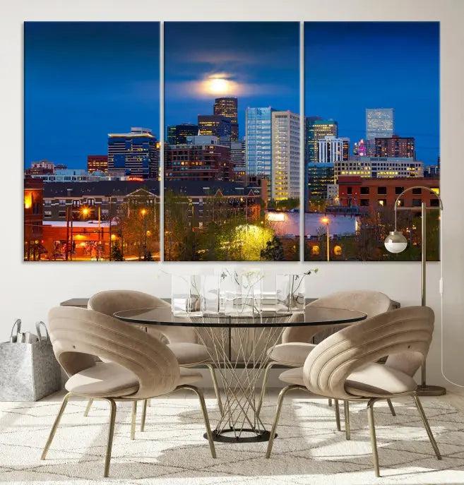 The Denver City Lights Night Blue Skyline Cityscape View Wall Art Canvas Print captures a stunning skyline at night with illuminated buildings and a bright moon, presented on gallery-quality canvas for an elegant display.