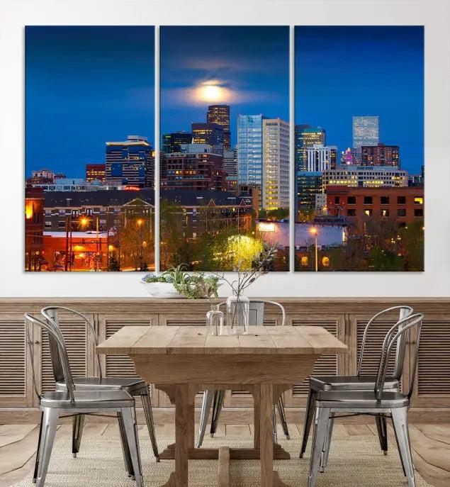 The Denver City Lights Night Blue Skyline Cityscape View Wall Art Canvas Print captures a stunning skyline at night with illuminated buildings and a bright moon, presented on gallery-quality canvas for an elegant display.