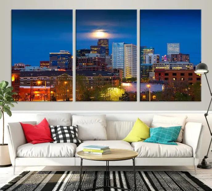 The Denver City Lights Night Blue Skyline Cityscape View Wall Art Canvas Print captures a stunning skyline at night with illuminated buildings and a bright moon, presented on gallery-quality canvas for an elegant display.