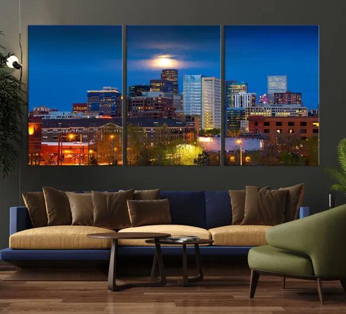 The Denver City Lights Night Blue Skyline Cityscape View Wall Art Canvas Print captures a stunning skyline at night with illuminated buildings and a bright moon, presented on gallery-quality canvas for an elegant display.