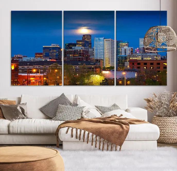 The Denver City Lights Night Blue Skyline Cityscape View Wall Art Canvas Print captures a stunning skyline at night with illuminated buildings and a bright moon, presented on gallery-quality canvas for an elegant display.