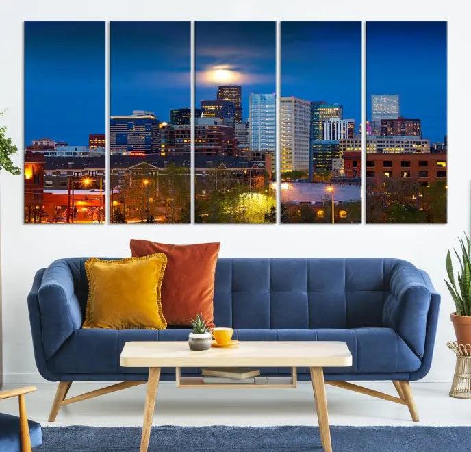 The Denver City Lights Night Blue Skyline Cityscape View Wall Art Canvas Print captures a stunning skyline at night with illuminated buildings and a bright moon, presented on gallery-quality canvas for an elegant display.