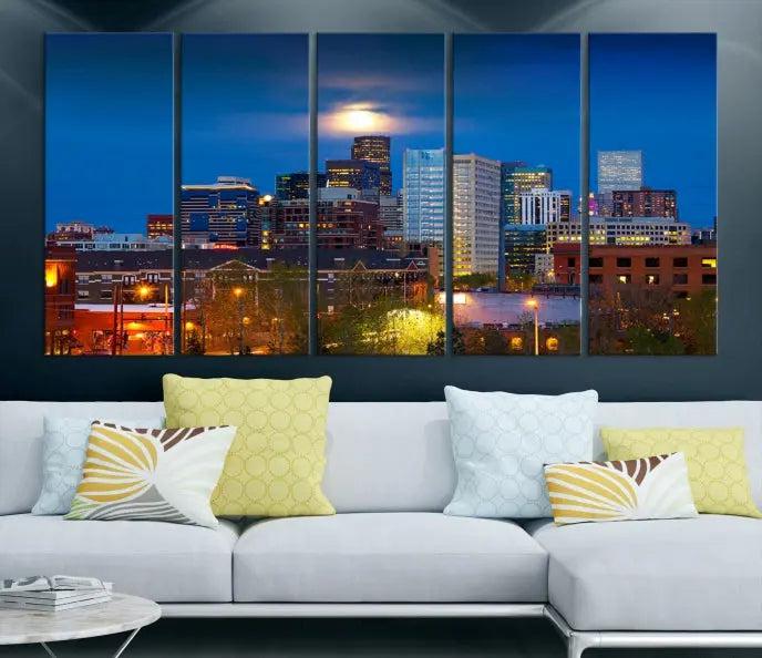 The Denver City Lights Night Blue Skyline Cityscape View Wall Art Canvas Print captures a stunning skyline at night with illuminated buildings and a bright moon, presented on gallery-quality canvas for an elegant display.