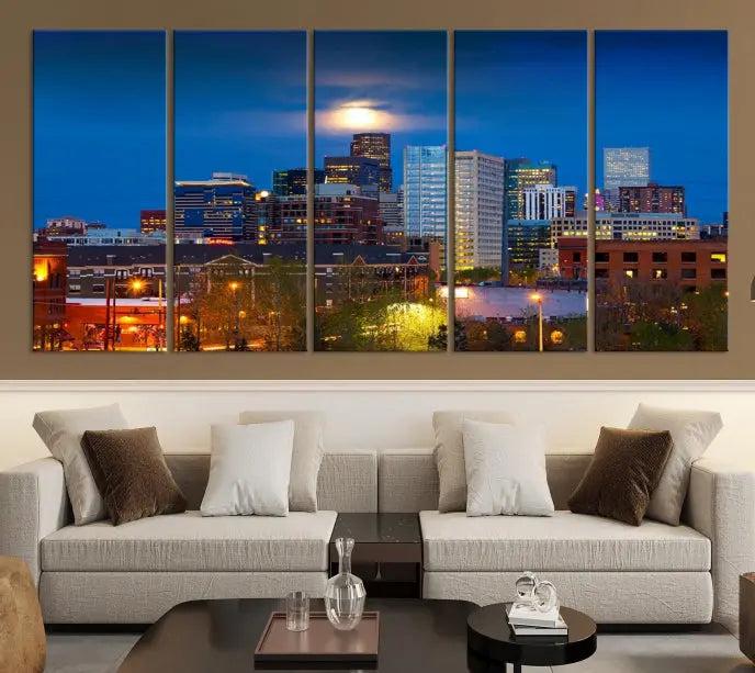 The Denver City Lights Night Blue Skyline Cityscape View Wall Art Canvas Print captures a stunning skyline at night with illuminated buildings and a bright moon, presented on gallery-quality canvas for an elegant display.