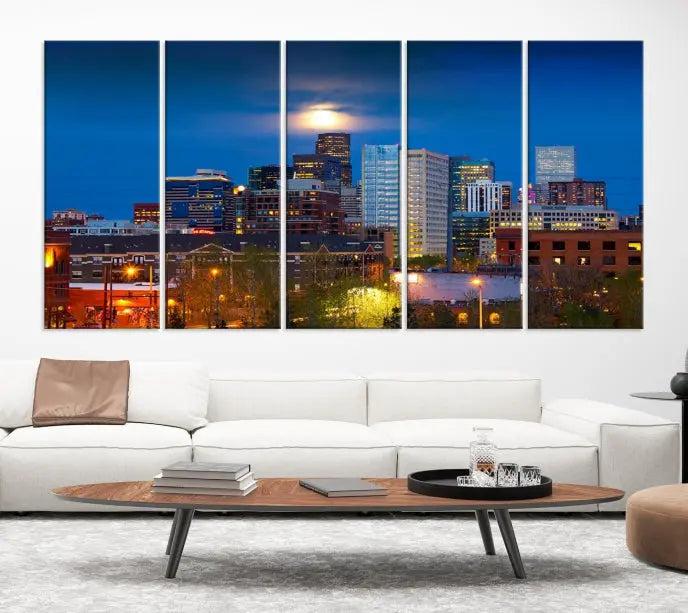 The Denver City Lights Night Blue Skyline Cityscape View Wall Art Canvas Print captures a stunning skyline at night with illuminated buildings and a bright moon, presented on gallery-quality canvas for an elegant display.