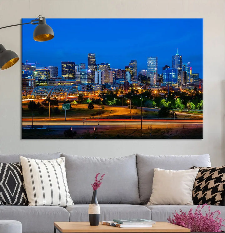 A modern living room showcases the "Denver City Lights Night Blue Skyline Cityscape View Wall Art Canvas Print" in a triptych arrangement. These museum-quality canvases, finished with a UV-protective coating, maintain their vibrant allure.