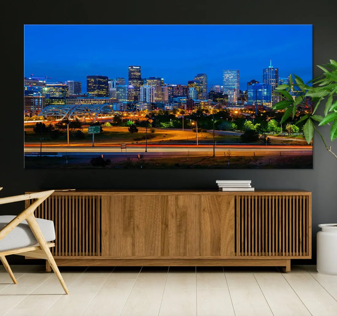 A modern living room showcases the "Denver City Lights Night Blue Skyline Cityscape View Wall Art Canvas Print" in a triptych arrangement. These museum-quality canvases, finished with a UV-protective coating, maintain their vibrant allure.