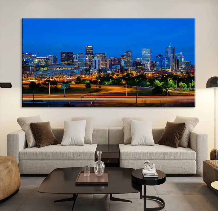 A modern living room showcases the "Denver City Lights Night Blue Skyline Cityscape View Wall Art Canvas Print" in a triptych arrangement. These museum-quality canvases, finished with a UV-protective coating, maintain their vibrant allure.