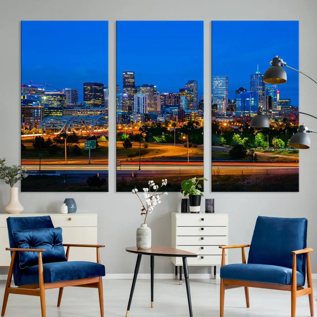 A modern living room showcases the "Denver City Lights Night Blue Skyline Cityscape View Wall Art Canvas Print" in a triptych arrangement. These museum-quality canvases, finished with a UV-protective coating, maintain their vibrant allure.