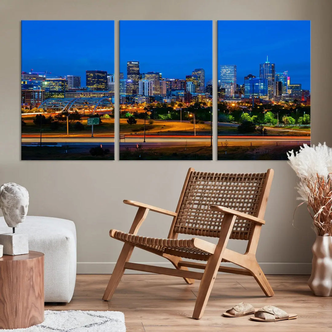 A modern living room showcases the "Denver City Lights Night Blue Skyline Cityscape View Wall Art Canvas Print" in a triptych arrangement. These museum-quality canvases, finished with a UV-protective coating, maintain their vibrant allure.