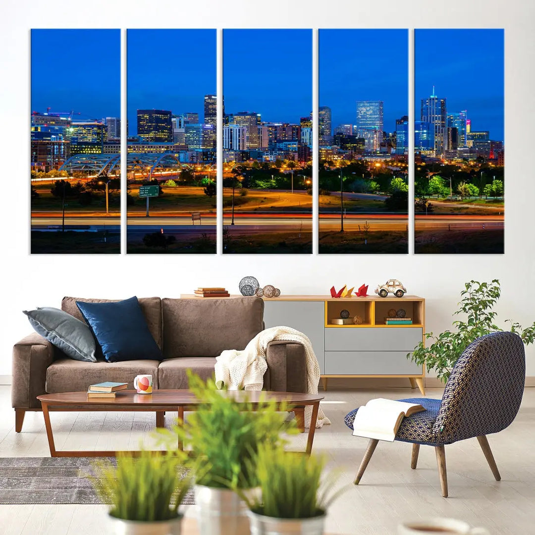 A modern living room showcases the "Denver City Lights Night Blue Skyline Cityscape View Wall Art Canvas Print" in a triptych arrangement. These museum-quality canvases, finished with a UV-protective coating, maintain their vibrant allure.