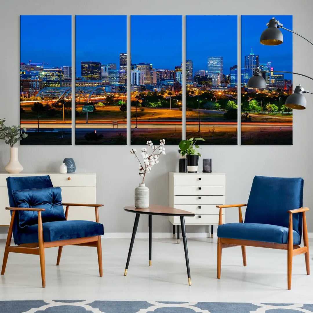 A modern living room showcases the "Denver City Lights Night Blue Skyline Cityscape View Wall Art Canvas Print" in a triptych arrangement. These museum-quality canvases, finished with a UV-protective coating, maintain their vibrant allure.