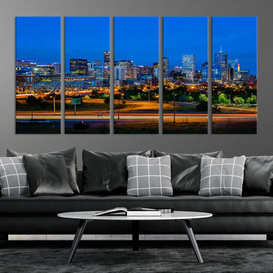 A modern living room showcases the "Denver City Lights Night Blue Skyline Cityscape View Wall Art Canvas Print" in a triptych arrangement. These museum-quality canvases, finished with a UV-protective coating, maintain their vibrant allure.