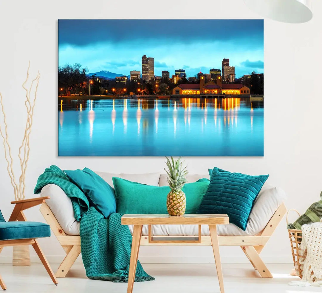 A living room in teal and brown decor showcases the "Denver City Lights Night Bright Turquoise Skyline Cityscape View" wall art canvas print above the couch. This large, museum-quality piece comes with a UV-protective coating.