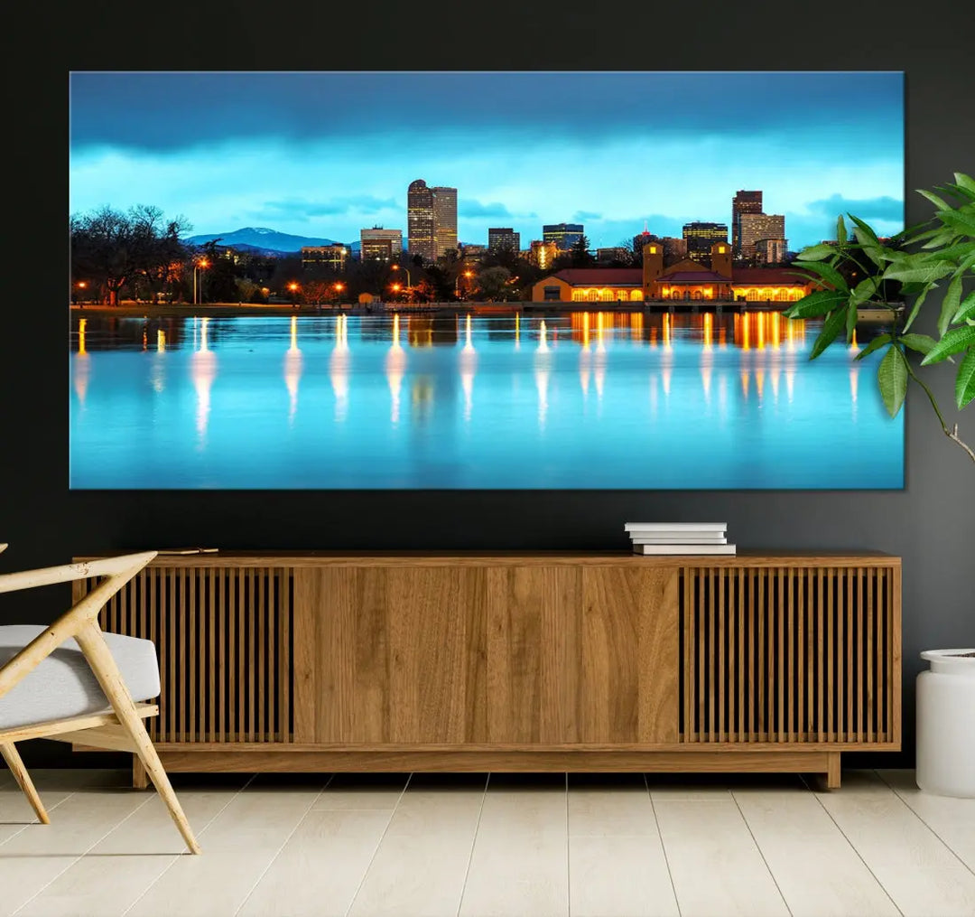 A living room in teal and brown decor showcases the "Denver City Lights Night Bright Turquoise Skyline Cityscape View" wall art canvas print above the couch. This large, museum-quality piece comes with a UV-protective coating.