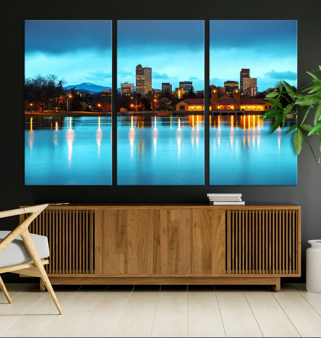 A living room in teal and brown decor showcases the "Denver City Lights Night Bright Turquoise Skyline Cityscape View" wall art canvas print above the couch. This large, museum-quality piece comes with a UV-protective coating.