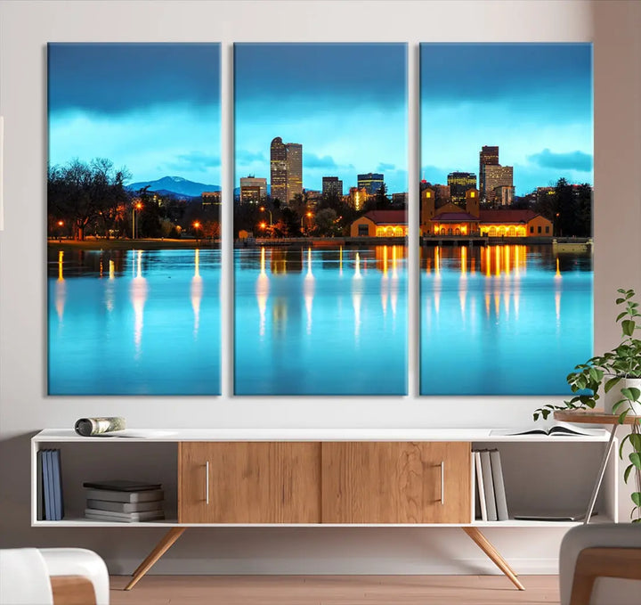 A living room in teal and brown decor showcases the "Denver City Lights Night Bright Turquoise Skyline Cityscape View" wall art canvas print above the couch. This large, museum-quality piece comes with a UV-protective coating.